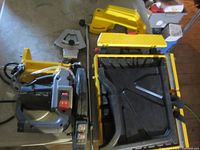 Disassembled tile saw components including motor, water tray, table, blade guard, fence