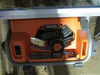Front underside of Ridgid orange table saw showing controls and branding
