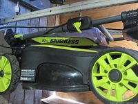Left side view showing Ryobi branding, 20in Brushless marking, wheels, and foldable handle