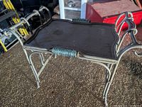 angled view of ornate metal tray side table showing scroll legs and turquoise glass handles