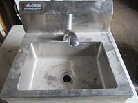 Front view of stainless steel hand sink showing basin, faucet and backsplash