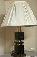 Front view of marble and brass table lamp with pleated shade