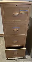 Front view showing all four drawers, beige metal finish, lock on top drawer
