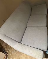 overall view of sofa showing three cushions and light gray fabric