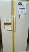 Full front view of refrigerator showing side-by-side doors, dispenser, and attached document