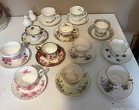 All six teacup and saucer pairs laid out on table