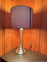Front view of lamp showing brushed silver base and dark charcoal shade