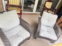 Pair of brown wicker armchairs with gray cushions