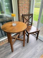 Round wooden table and wooden chair side by side