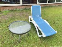 Chaise lounge and side table on lawn, full view