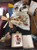 Overview of table with multiple Christmas ornaments and decorations including glass ornaments and wooden figurines