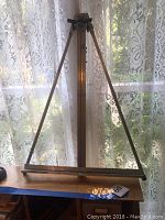 Wooden table top easel standing upright, shown fully extended with adjustable vertical support and horizontal base.