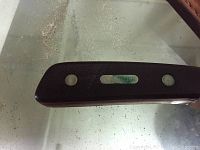 Close up of folding knife handle marked 'Old Timer' with dark textured handle and metal rivets.