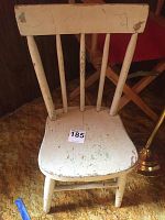 Top view of vintage white wooden chair showing heavy paint chipping and cracking.