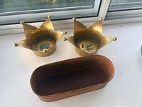 Brass crown bowls and copper trough grouped on windowsill