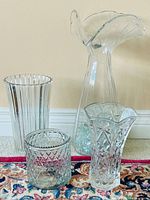 Group shot of four clear glass vessels showing patterns and sizes