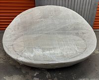 Entire round sofa wrapped in plastic, front view