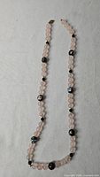 Full view of rose quartz bead necklace showing length and bead arrangement