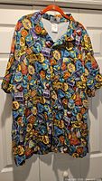 Front view of Disney Parks attractions button-up shirt on hanger