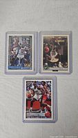 Three sleeved Shaquille O'Neal cards laid out