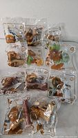 Nine of the ten sealed Lion King Happy Meal toys arranged on table