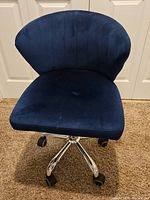 Front view of navy suede swivel chair showing seat, backrest, chrome base and casters