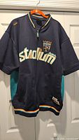 Full front view of navy Akademiks Stadium jacket on hanger