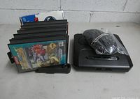 Front view showing console, controller in plastic, stack of seven game cases
