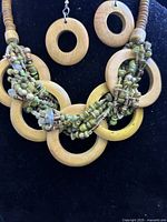 Full view of necklace and earrings showing wood rings and bead detailing