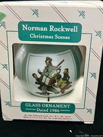 Front view of ornament in original Hallmark box showing Norman Rockwell artwork and product details