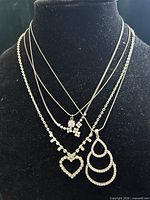 All four silver-tone rhinestone necklaces displayed on bust