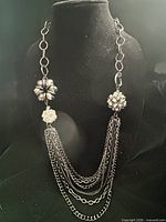 Full view of necklace on display form showing multi-strand chains and decorative clusters