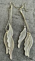 Full view of both silver-tone leaf dangle earrings