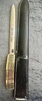 Letter opener and sheath side by side, showing Greek key handle and sheath texture
