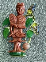 Full view of brooch showing figure, leaves, crystals