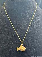 Full view of necklace on display bust showing chain and pendant