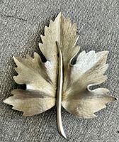 Front view showing textured silver-tone maple leaf design