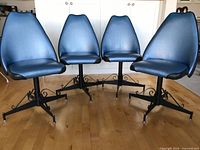 Front view of four blue vinyl swivel chairs