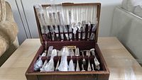 Open flatware chest showing entire assortment of wrapped and unwrapped pieces