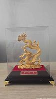 Dragon figurine inside acrylic case on wood base