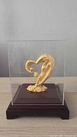 Front view of gold tiger figurine inside acrylic case on wood base