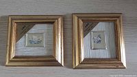 Front view of both gold square frames with miniature prints