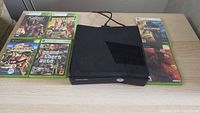 Console centered on table with six game cases around it