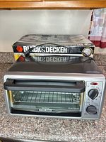 Front view of Black & Decker EventToast toaster oven with box visible behind
