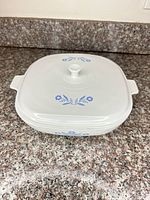 casserole side view with lid on, showing cornflower graphic and handles