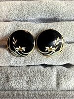 Front view of both round floral enamel clip-on earrings