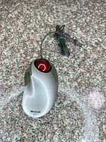 Full view of Microsoft Trackball Explorer showing silver body, red ball and attached cable