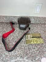 Leather half-case, strap, instruction manual