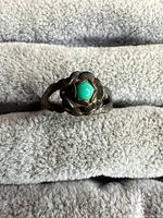 Front view showing turquoise cabochon in floral bezel