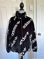 Front view of black faux fur Adidas jacket on mannequin